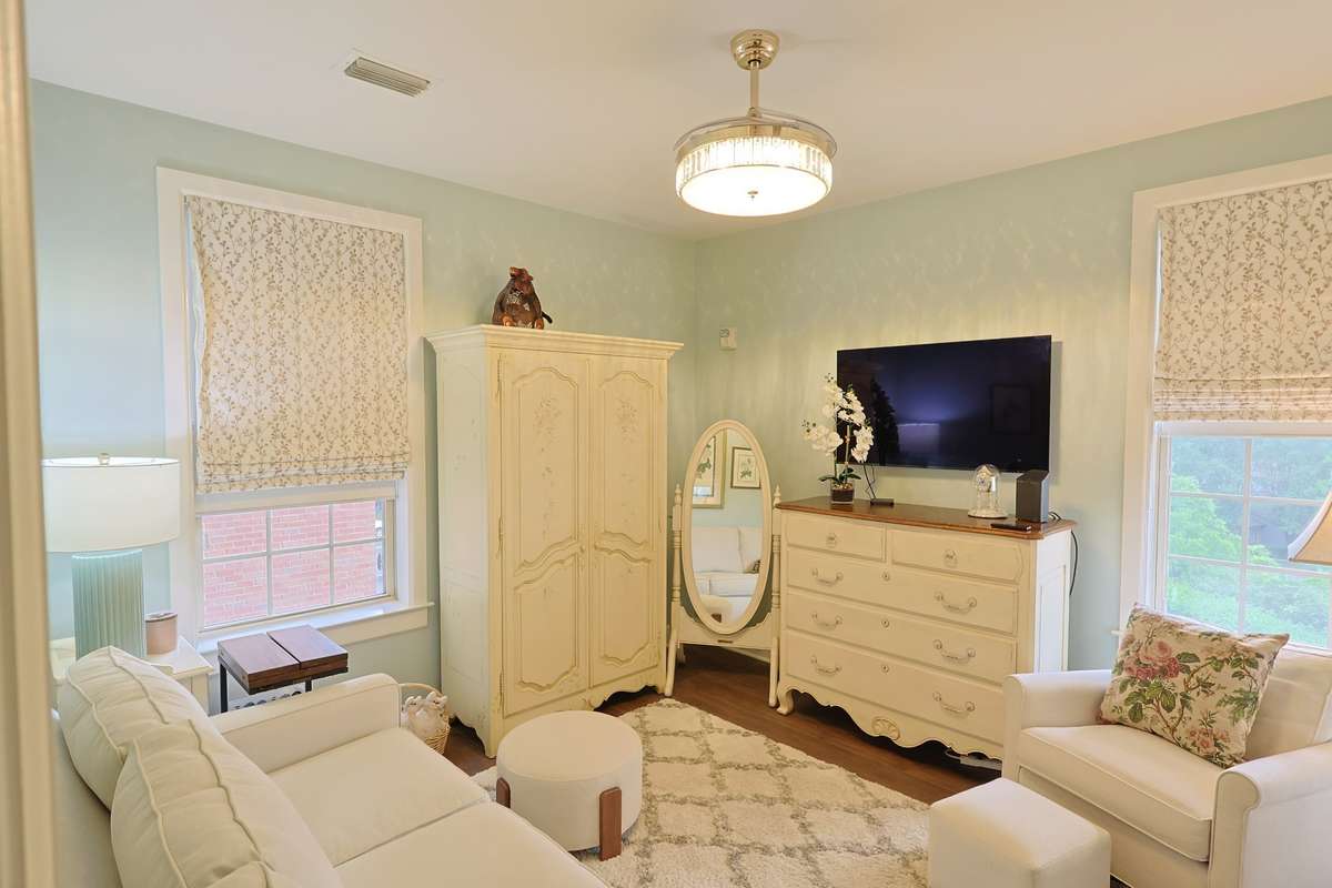 Bedroom 2 is being utilized as a sitting room with a sleeper sofa for guests. This space overlooks the beautiful grounds behind the building and greenery from spring to autumn.