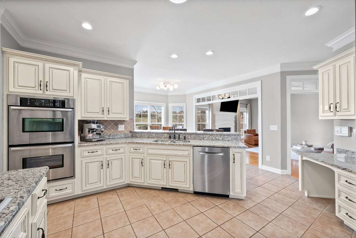 Look at this space, beautiful stainless appliances with a double oven, neutral tile, built in custom desk, oil rubbed bronze hardware and notice how wonderful this open floor plan is for watching TV or the kids doing homework.