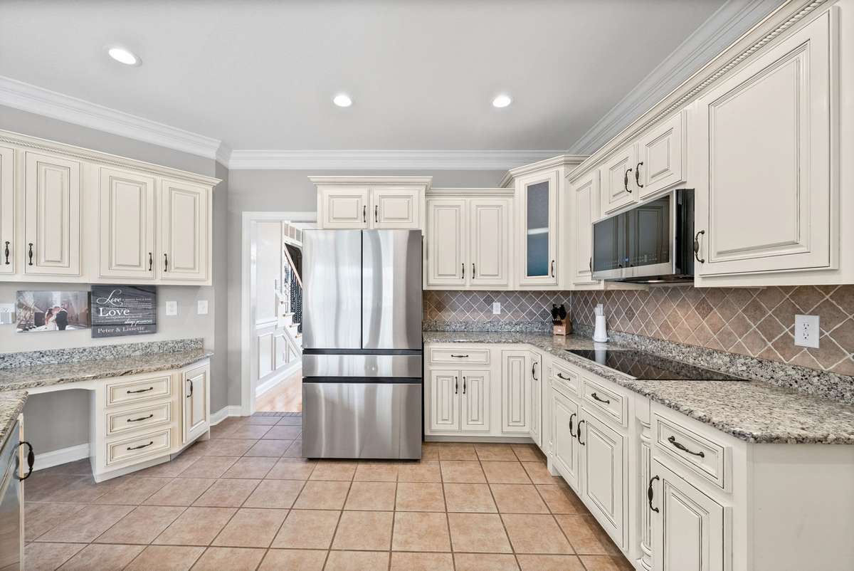You won't believe the incredible amount of counter top space, and look at how lovely your designer tile backsplash is. Also this kitchen offers a wonderful pantry and is located just down the hall to your oversized laundry room with storage cabinets.