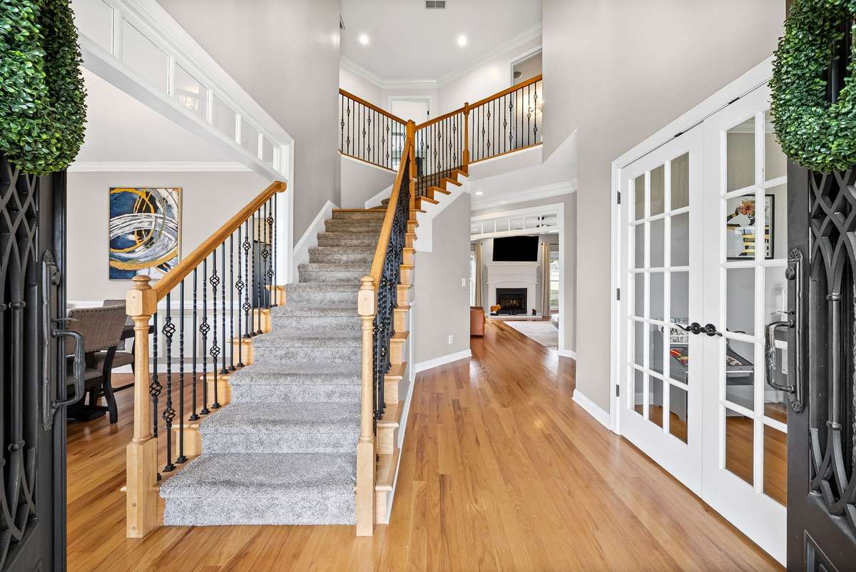 From the moment you walk into this Gorgeous Custom Home, with Soaring Ceilings, and Architectural delights such as new luxurious lighting selections with dimmers, Transom Windows, Iron Railing, French doors, and Gleaming Hardwood floors throughout.