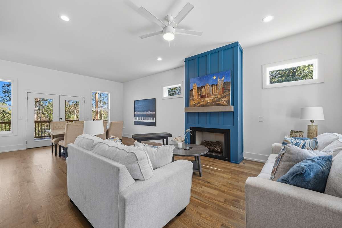 Open living area featuring hardwood floors, abundant natural light, and a striking accent fireplace.