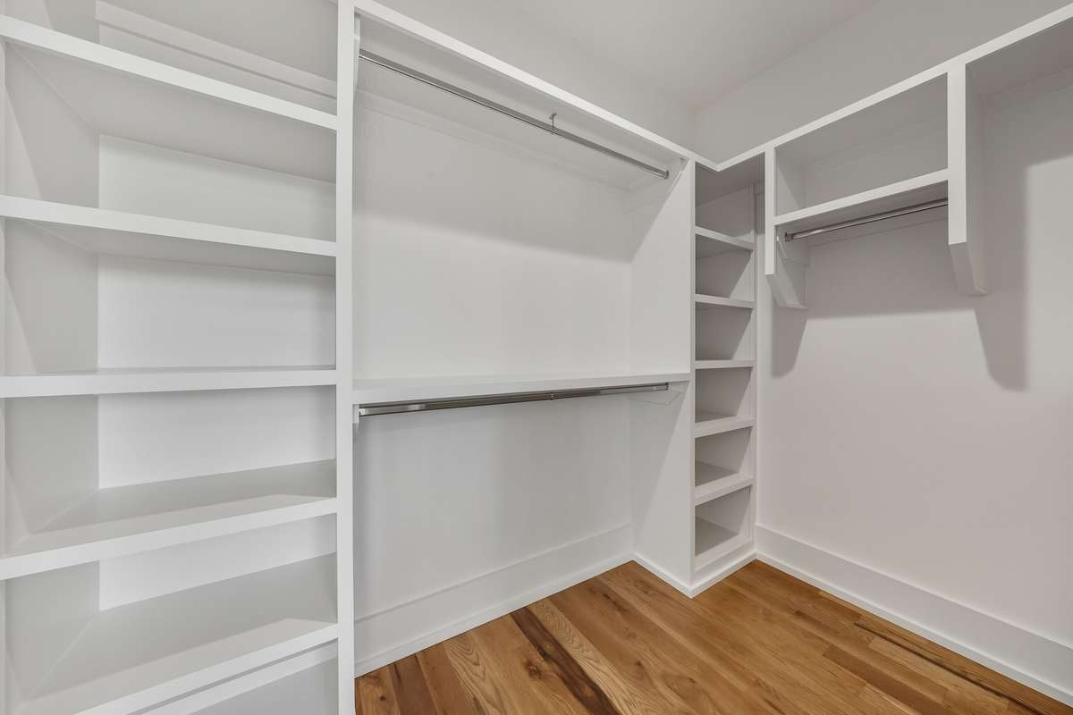 Walk-In Closet – Custom built-ins and multiple hanging spaces provide organized storage.