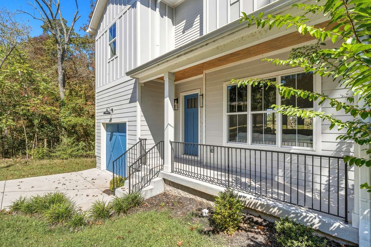 Modern two-story home with board-and-batten and lap siding, accented by a bold blue garage door and trim.