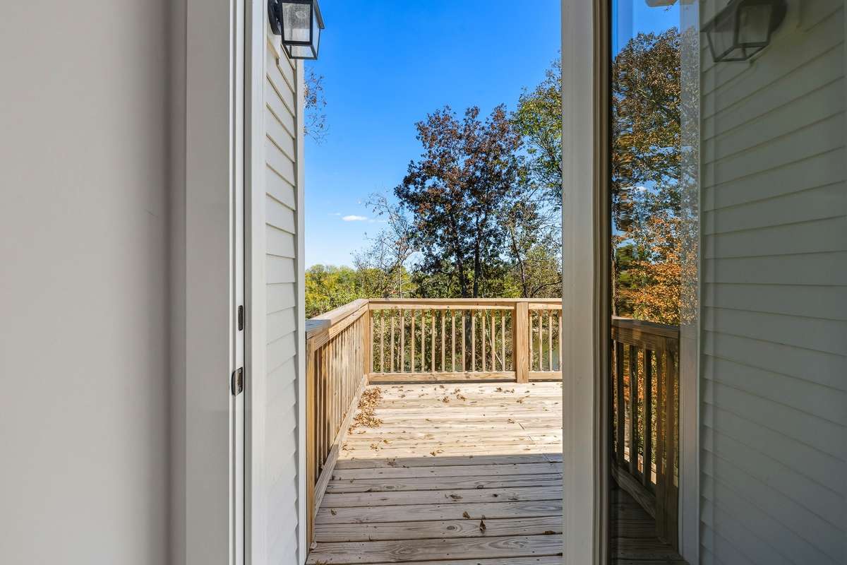 Private deck access through sliding glass doors, offering a seamless transition from indoor living to outdoor relaxation.