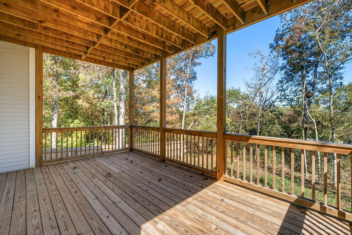 1st level Deck – Outdoor deck with wood railing overlooks peaceful tree-lined views.