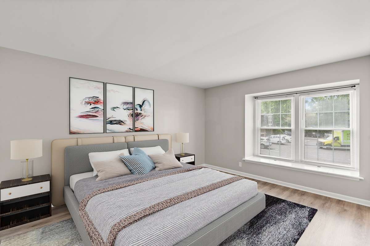 The first Bedroom offers lots of natural light, en suite Bathroom, luxury vinyl floors, fresh paint, and a spacious closet. (Virtually staged.)