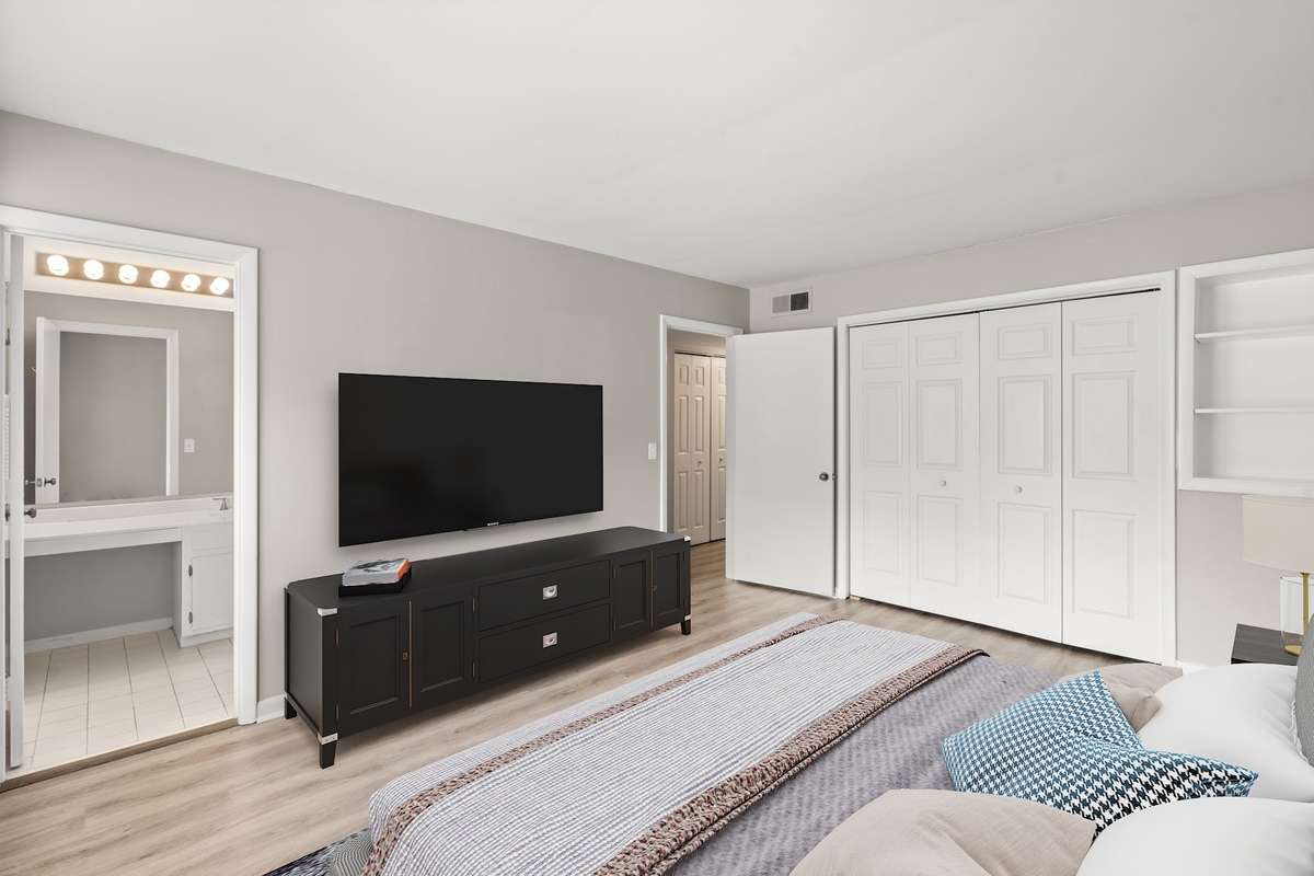 The first Bedroom offers lots of natural light, en suite Bathroom, luxury vinyl floors, fresh paint, and a spacious closet. (Virtually staged.)