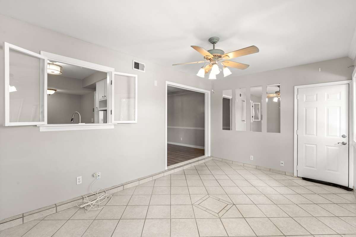 The bright Florida Room opens to the Kitchen and Dining Room. Extra windows and views of the many mature treetops offer a serene and elevated feel.