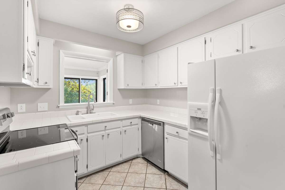 The updated Kitchen, situated just off of the Formal Dining Room, includes an eat-in nook, updated stainless steel stove/oven/dishwasher, new stackable washer/dryer unit, and lots of storage and countertop space. Opens to the Florida Room.