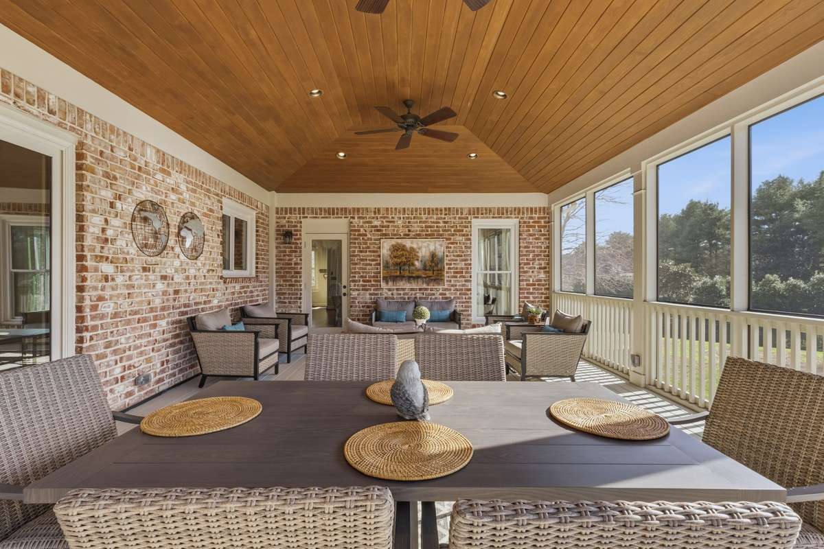 A large, fully screened porch finished with high end details and upscale materials - offering an elegant outdoor living space
