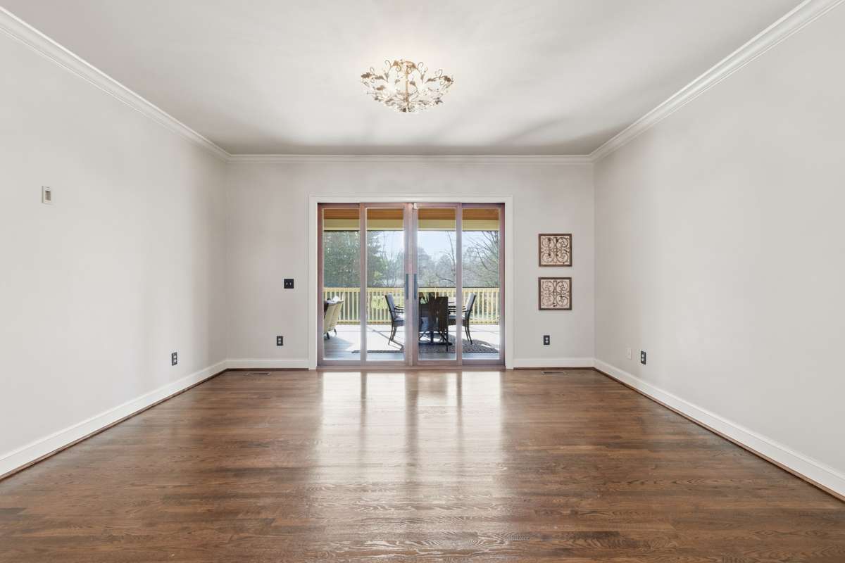 Living room with beautiful hardwoods and double doors leading to screened in porch