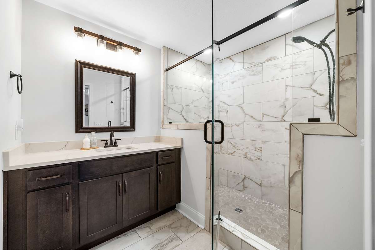 Stylish barn doors slide open to reveal another beautifully tiled en suite bathroom.
