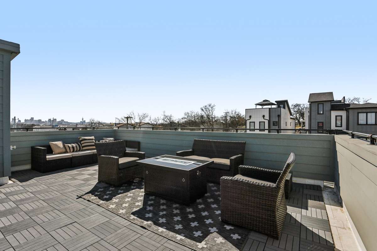 Spacious rooftop terrace with multiple seating areas and city views, offering ample room for dining and outdoor lounging.