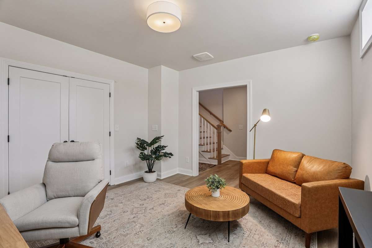 Flexible lower-level room located just off the staircase, offering a great setup for a home office, den, or additional living space.