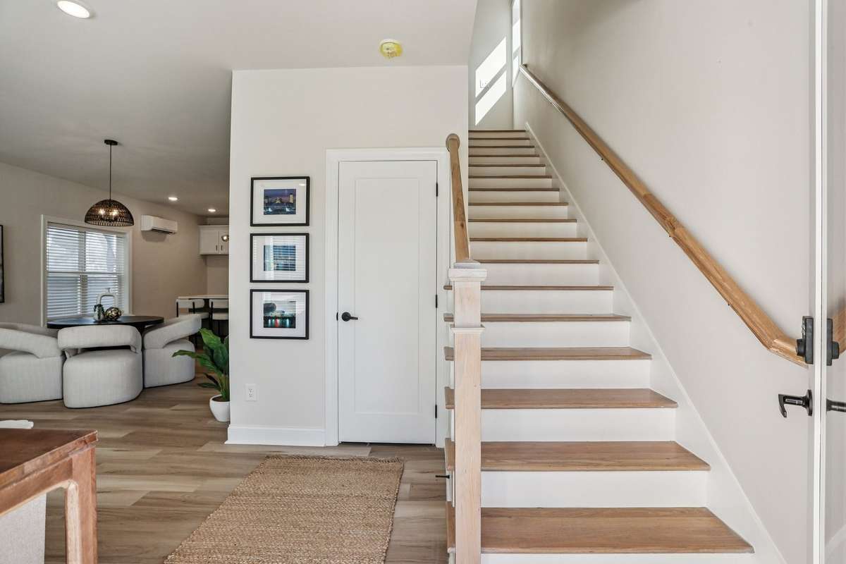 Conveniently positioned staircase off the main living space provides quick access to the upper level and complements the home’s open design.