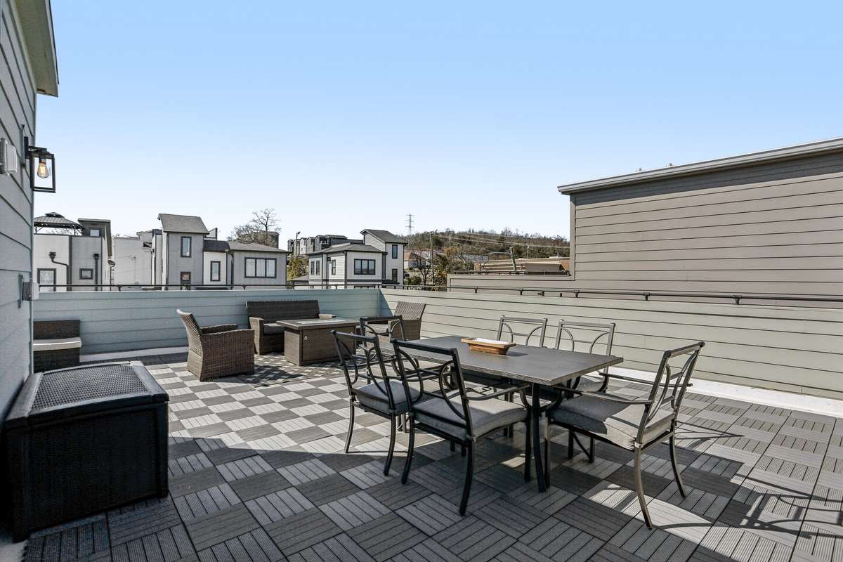 Spacious rooftop terrace with multiple seating areas and city views, offering ample room for dining and outdoor lounging.
