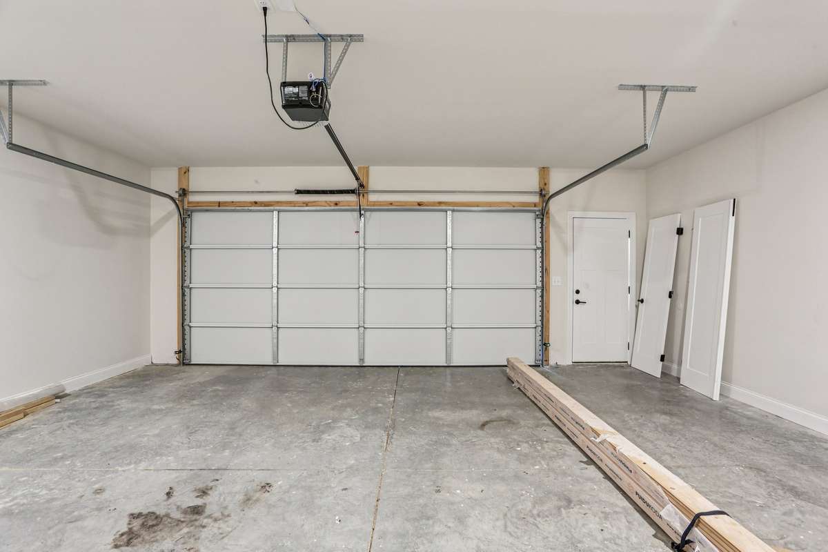 Spacious attached two-car garage with overhead door and room for additional storage. Finished with durable concrete flooring.