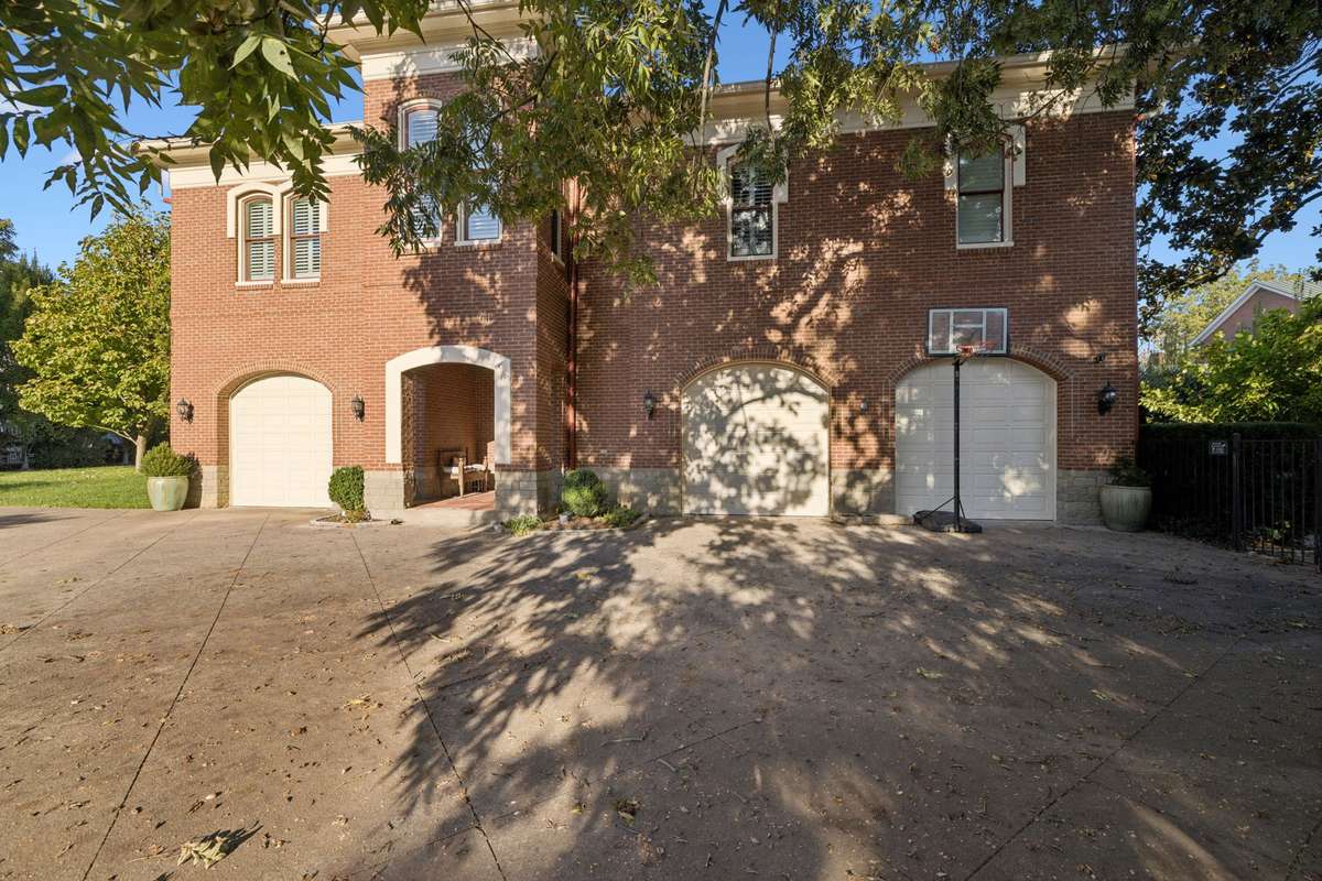 A three-car garage and expansive driveway provide abundant parking.