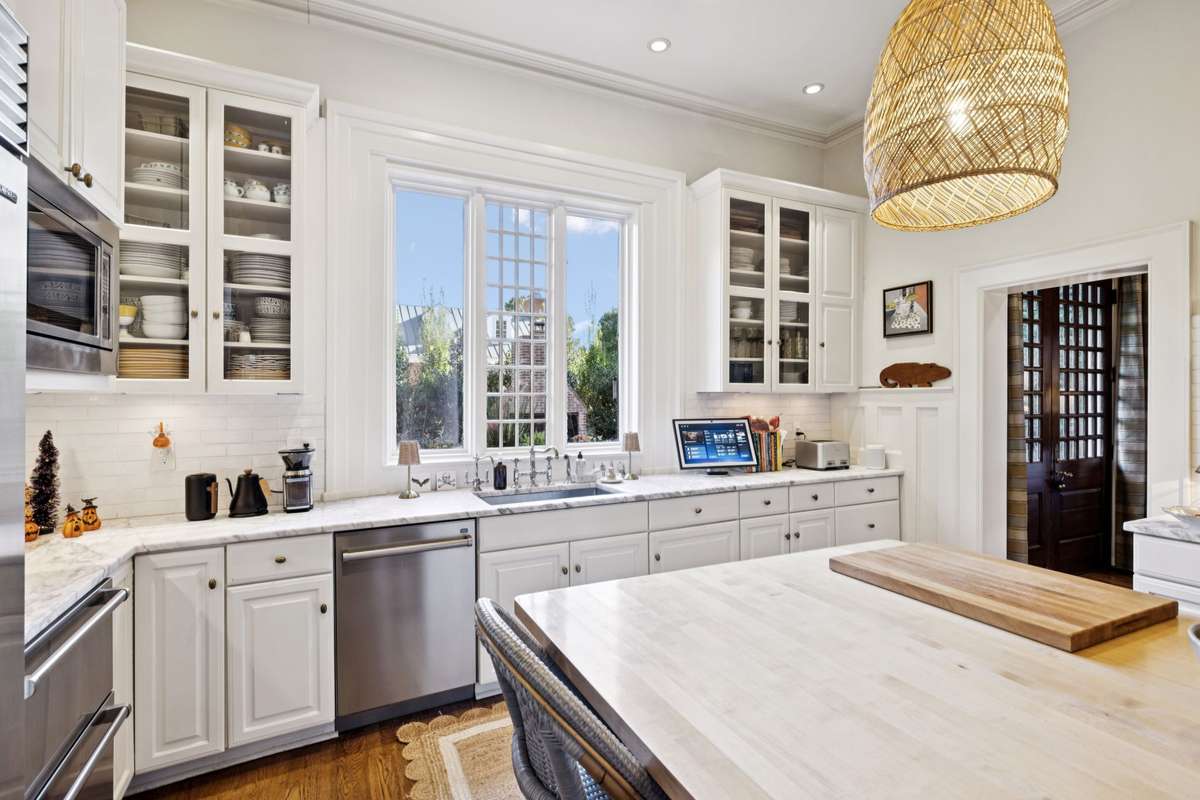 Oversized kitchen windows frame breathtaking views of the beautifully manicured gardens.