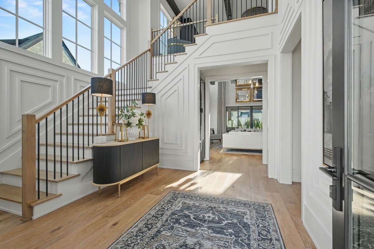 Welcoming Two Story Entry with Detailed Millwork and Restoration Hardware Chandelier - Bedroom #2 to the Right