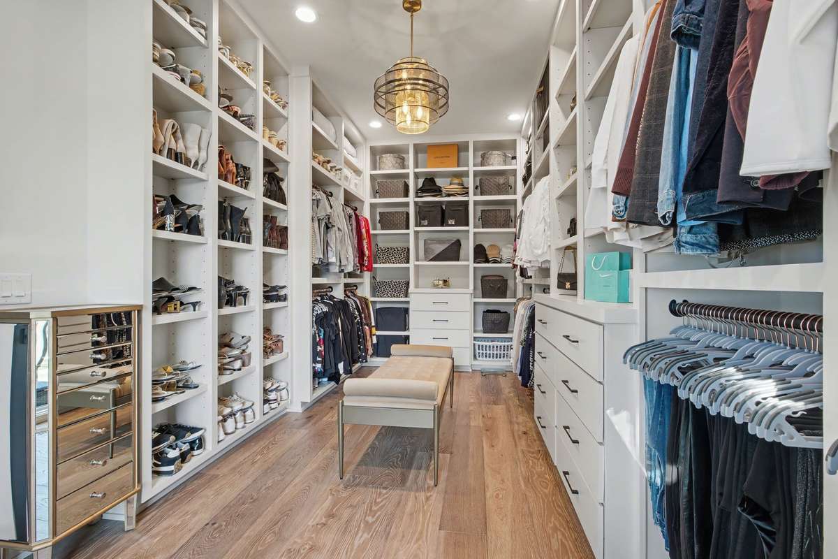 One of TWO (His & Hers) Master Bedroom Walk-in Closets Featuring Extensive Built-in Cabinetry and Multiple Hanging Areas & Drawers/Cabinetry/Storage