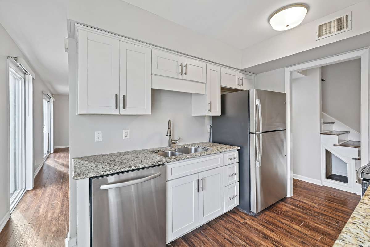 kitchen with stainless appliances, shaker cabinets and granite surfaces