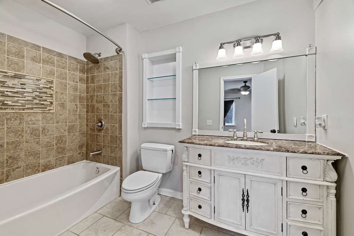 The vanity in the primary ensuite is so pretty!. Marble and tile throughout