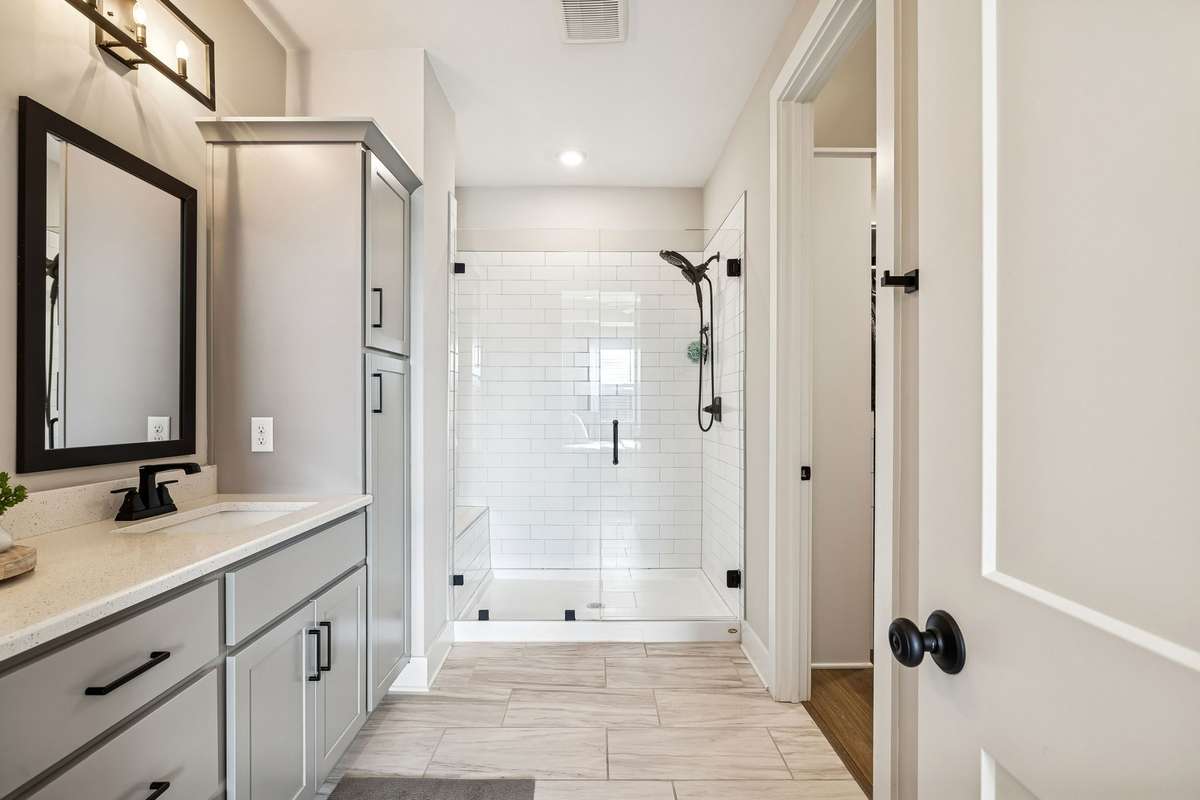 Primary bathroom features a double vanity, large linen cabinets and large walk in shower.