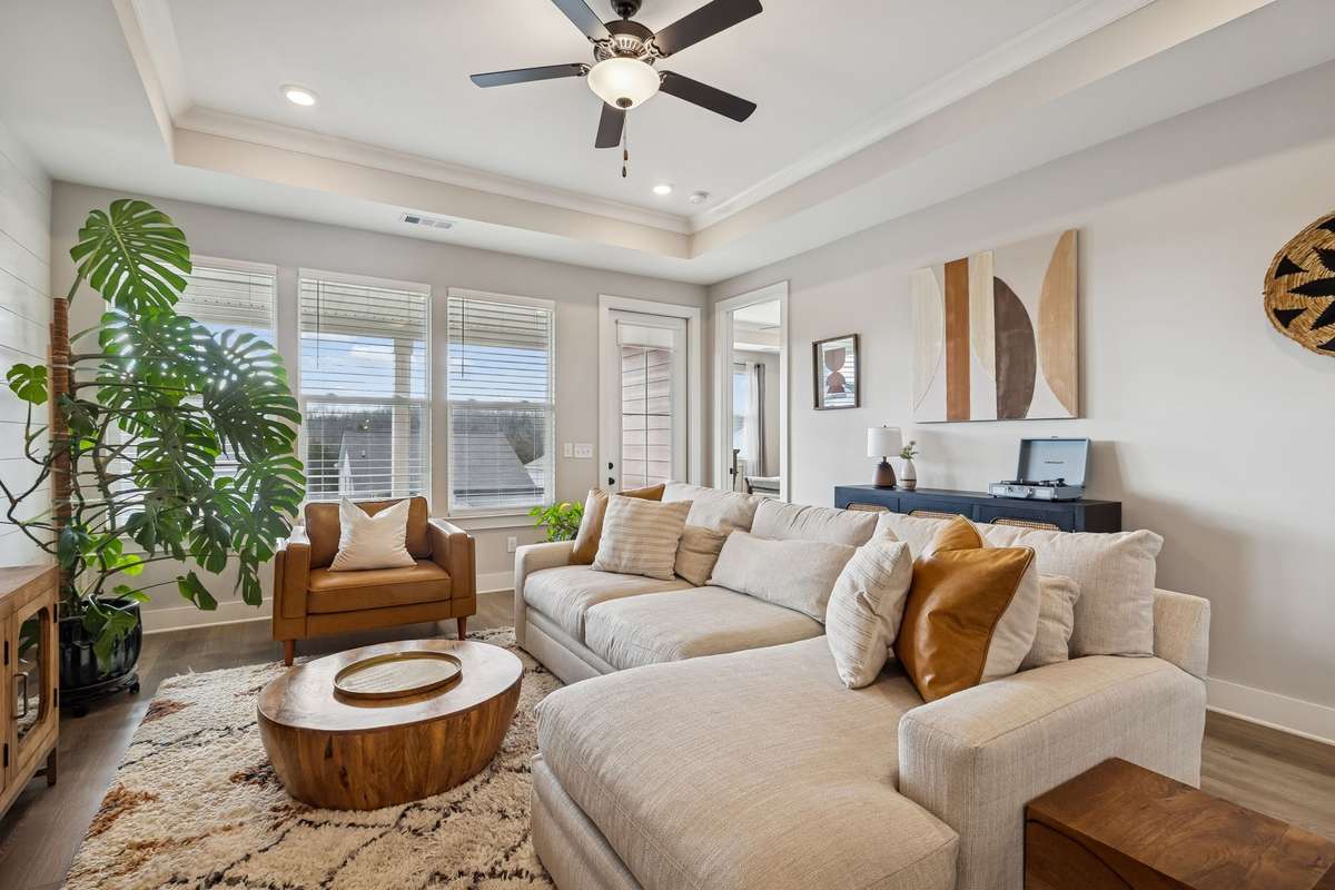 Trey ceiling, ceiling fan, and access to covered patio from the living room.