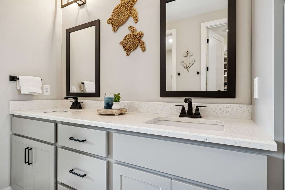 Primary bathroom double vanity with ample storage.