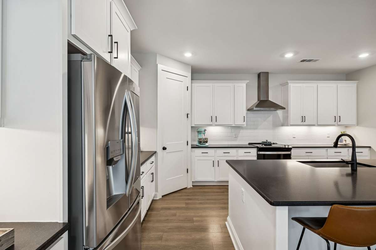 Wired under the spacious pantry, counter lights, black granite countertops, and single basin sink.