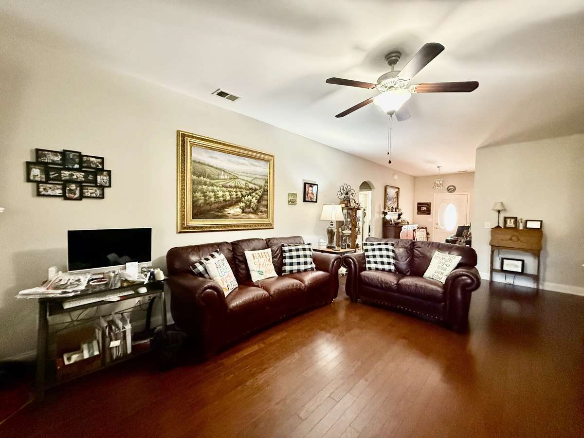 spacious 23x14 Living Room showcases a beautiful gas fireplace with a white mantle and flows seamlessly into the eat-in kitchen with bar-top seating, creating an inviting space for everyday living and entertaining.