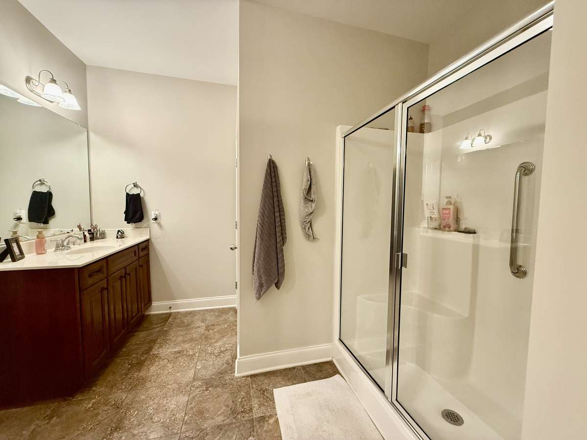 Primary Bath Suite offers walk-in shower, separate double vanities, and an extra-large closet; Tile floors; custom vanities with marble vanity tops;
