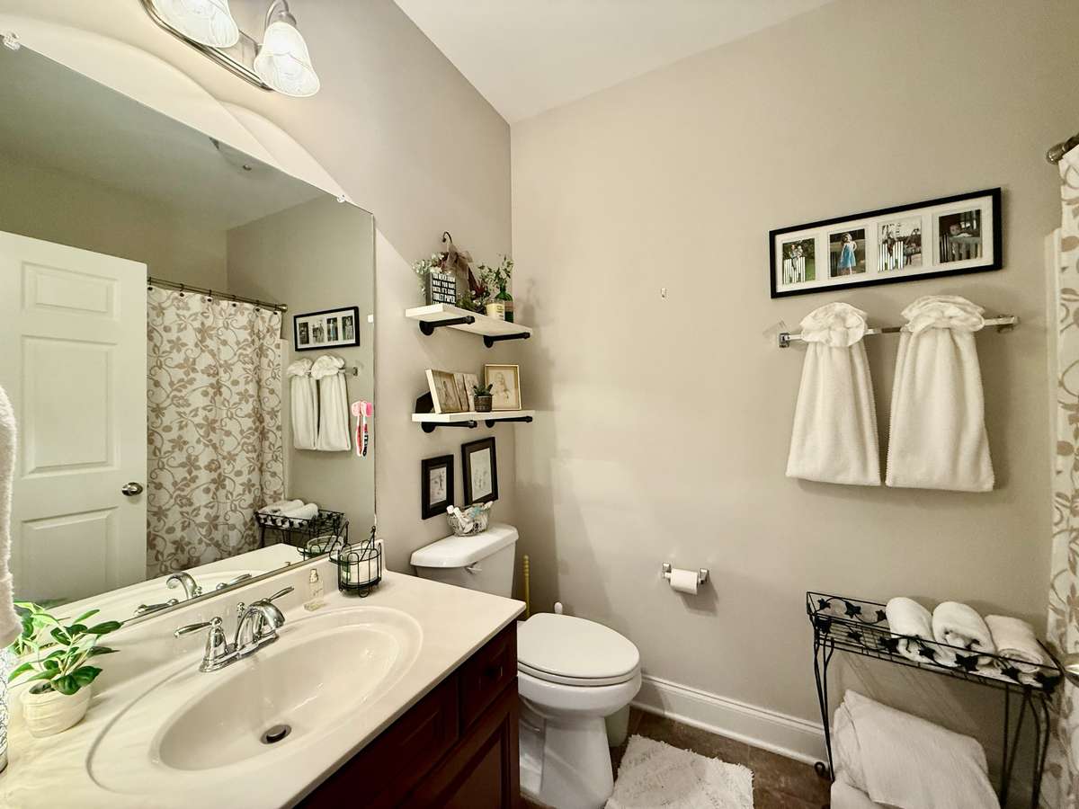 Hall Bath with tub/shower combo, single custom vanity with marble top; hardwood flooring