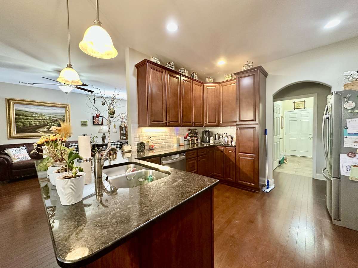 Spacious Kitchen with granite tops and custom cabinets; Under cabinet lighting; Pendants over the bar top for quick bite or study area