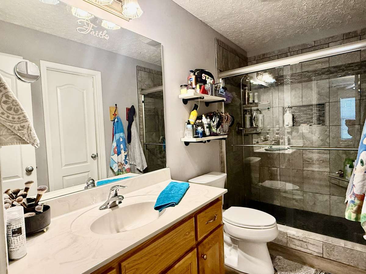 Primary Bath with walk-in tile shower; 5 ft custom vanity with marble top; walk-in closet; laminate flooring