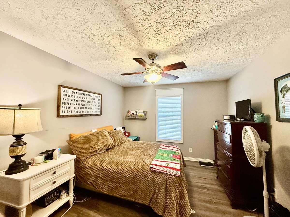 Primary Bedroom with laminate flooring walk in closet