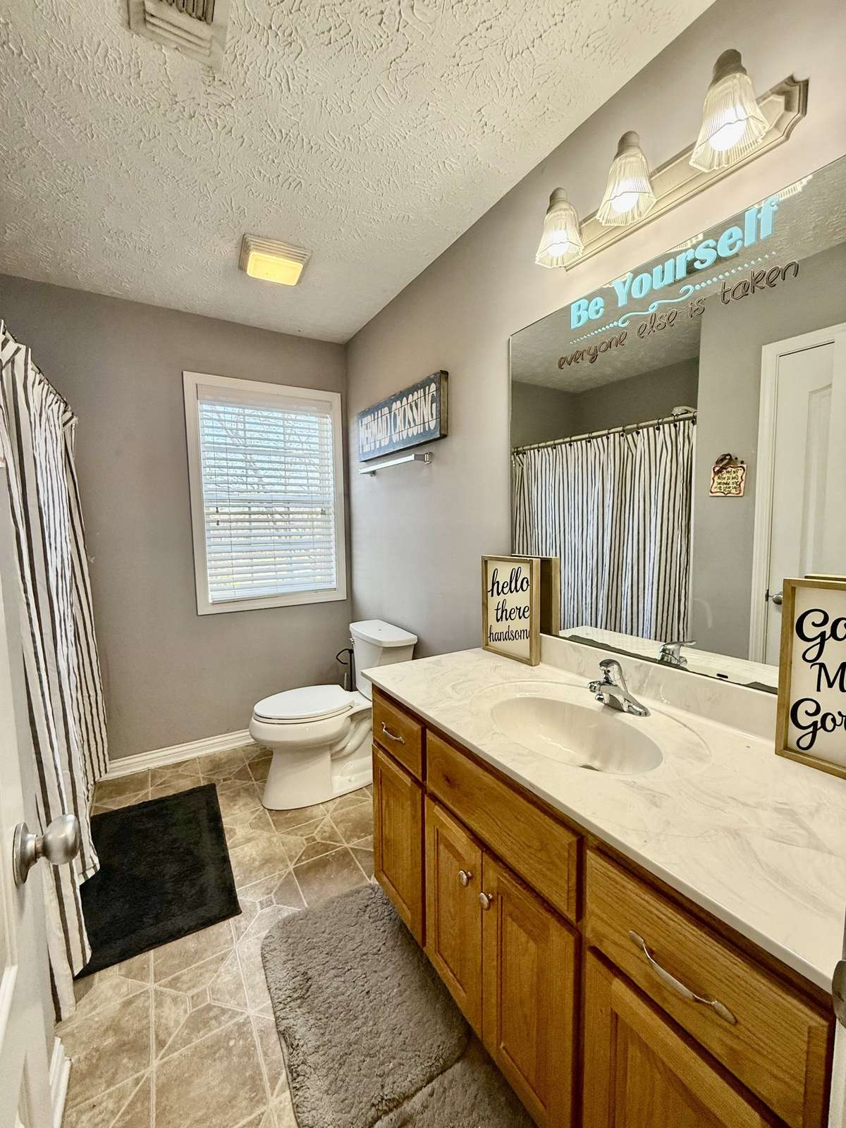 Upstairs Hall Bath with tub/shower combo; 6 ft custom vanity with marble top single sink; laminate flooring