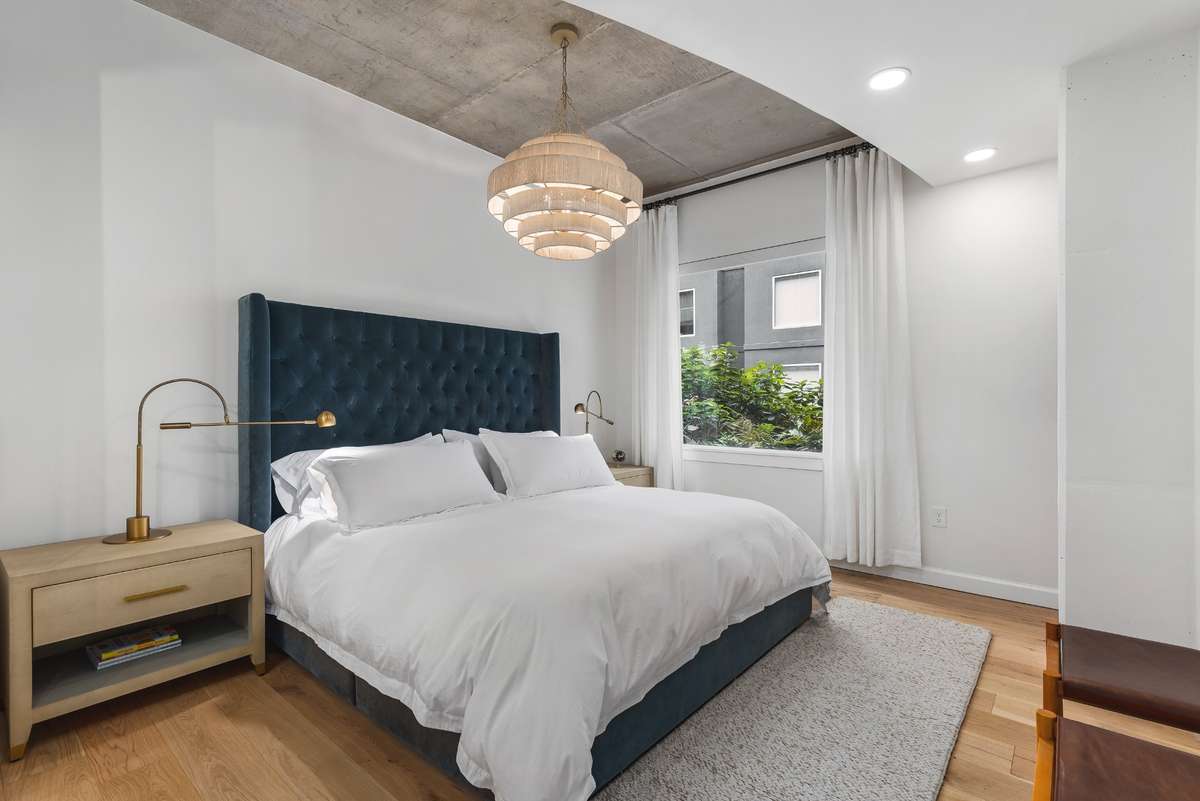 Primary suite with motorized shades with additional blackout rollout for lightly shaded or complete light blockage or enjoy the greenery from bed.