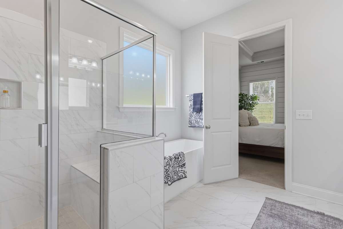 Primary bath fully-tiled shower and large soaking tub.