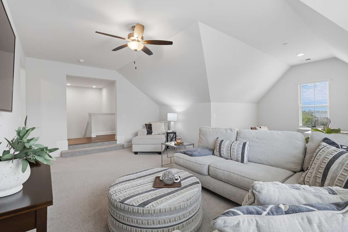 Another view of the bonus room toward the upper level landing.  Built-in bookshelf and storage closet on landing.