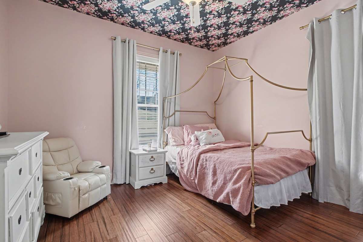 Look at this sweet room! Ceiling boasts a designer wallpaper pattern that adds a special touch to this room!