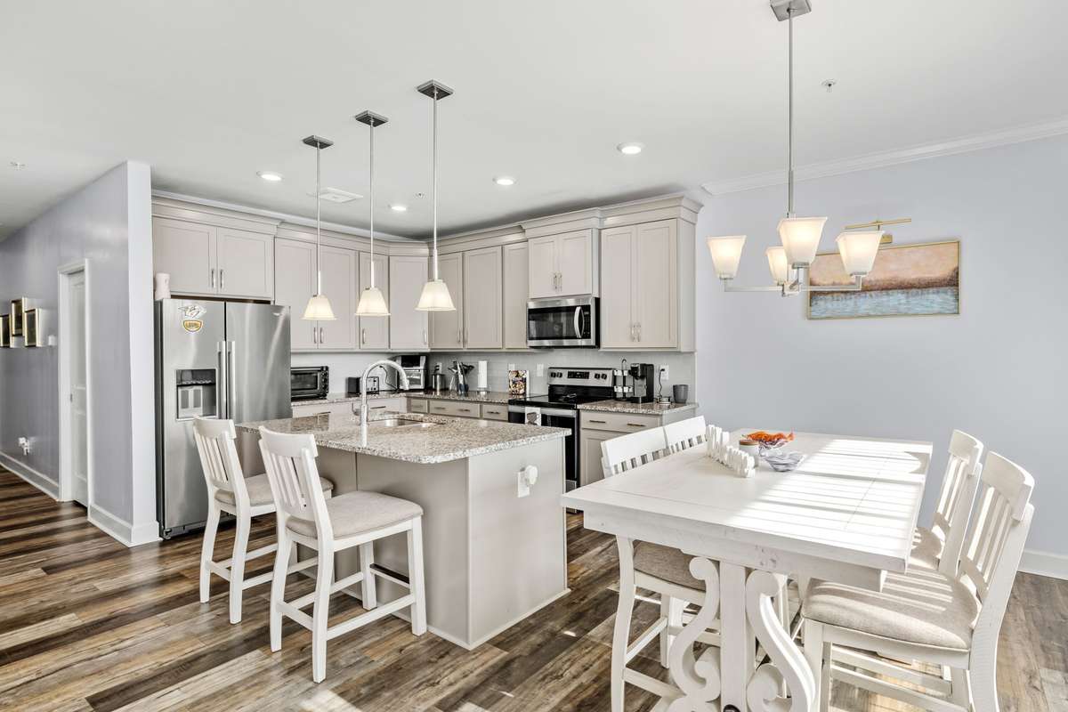 Open-concept kitchen and dining area filled with natural light and highlighted by elegant pendant lighting. The spacious island and adjacent dining space create a seamless setting for everyday meals and entertaining.