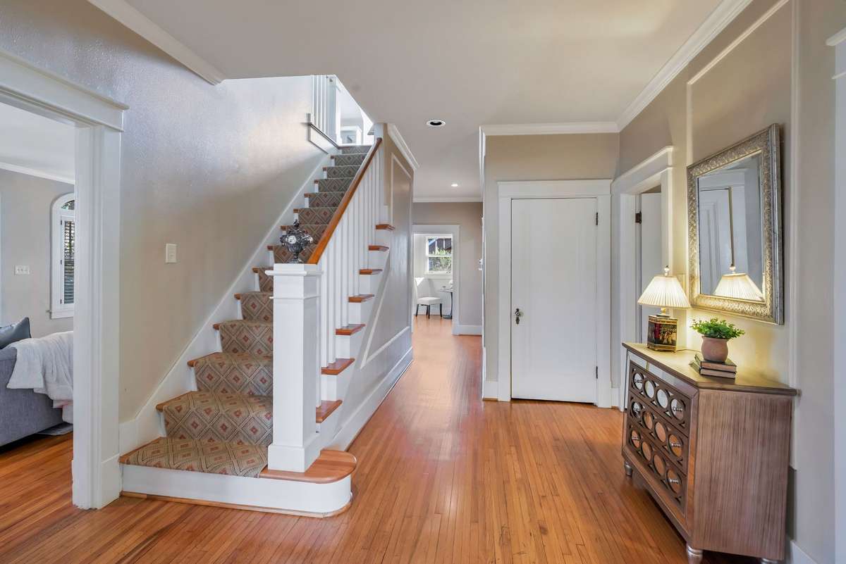 Central Hallway Leads you Up the Primary Suite w Sitting Rm and 2 Bedrooms and 2 Full Baths on the Main level. There is a convenient coat closet and stairs down to the encapsulated basement