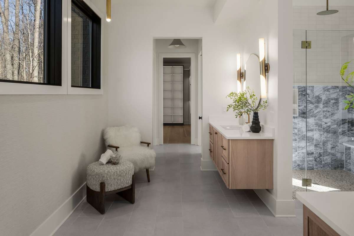 Primary bathroom hallway featuring floating vanities, modern lighting, and a spa-inspired layout that leads seamlessly to the custom closet and shower suite.