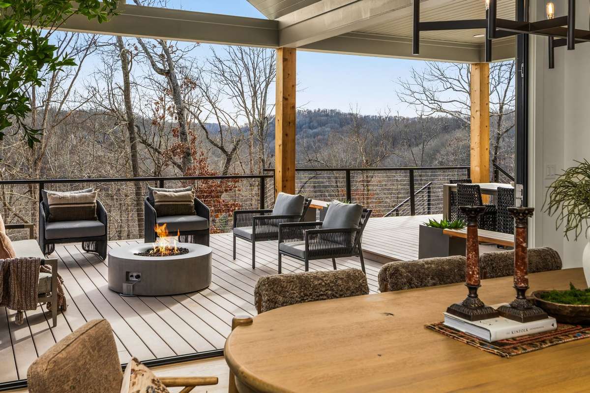 Covered outdoor living area featuring a gas fire pit, comfortable seating, and elevated valley views, designed for year-round entertaining and seamless indoor outdoor living.