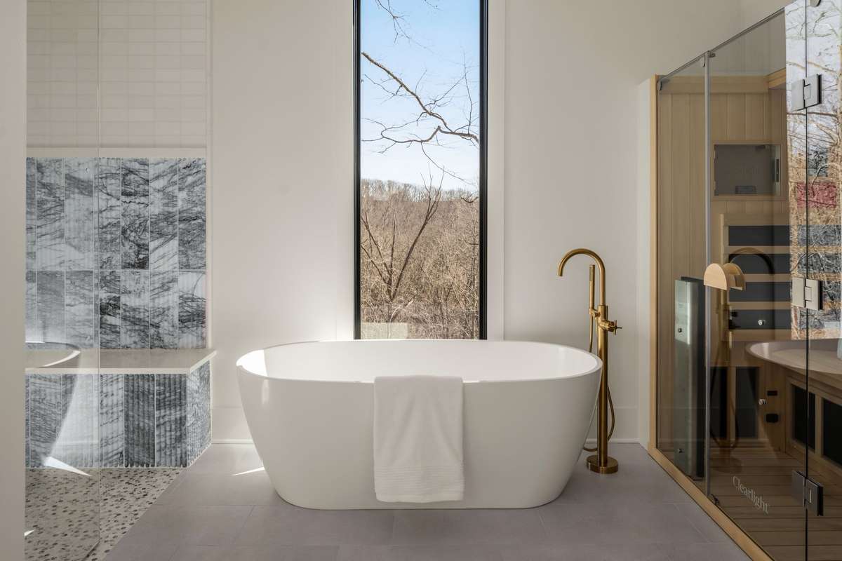 A spa worthy retreat with a sculptural soaking tub, sauna, and serene woodland views — designed for slow mornings and even slower evenings.