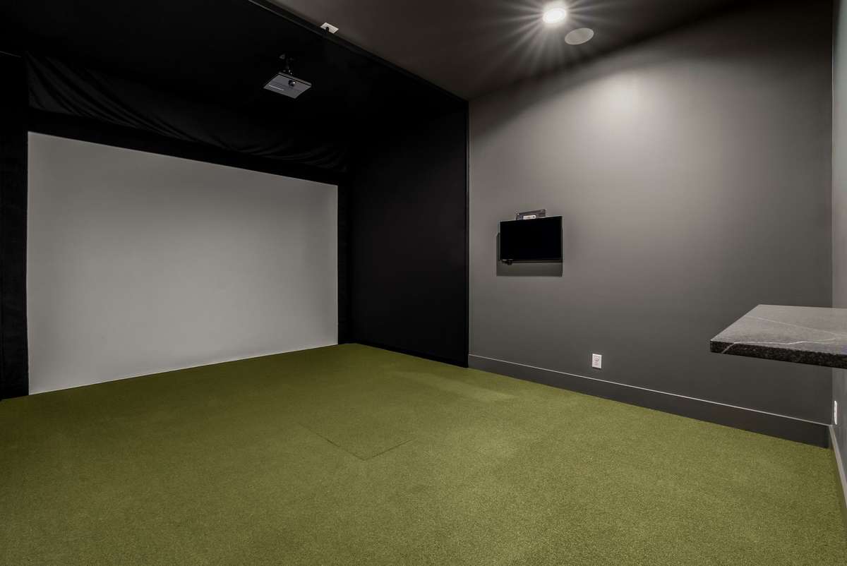 A dedicated golf simulator room designed to easily transform into a private home theater.