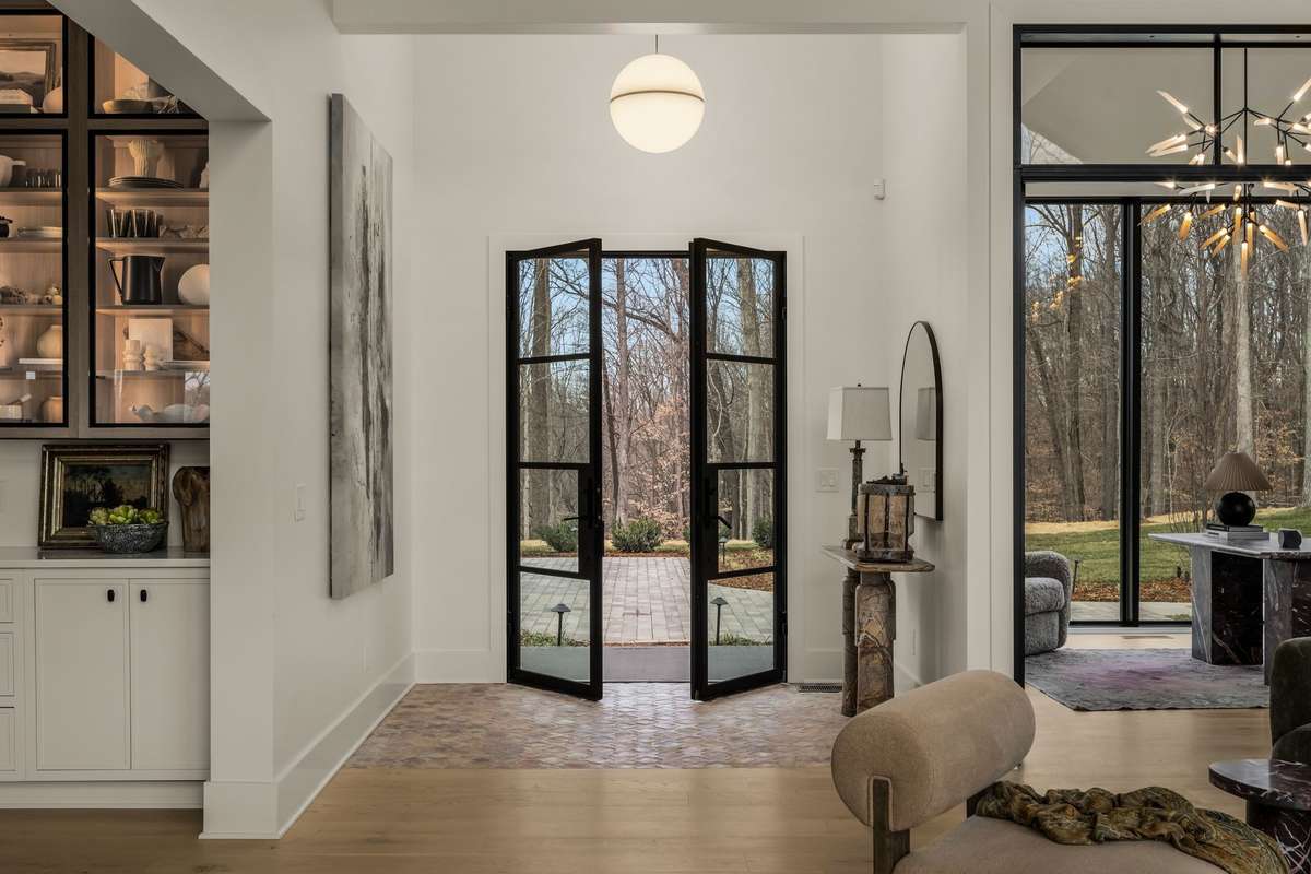 Front entry featuring elegant double doors, refined architectural detailing, and a welcoming transition that sets the tone for the thoughtfully designed interiors beyond.