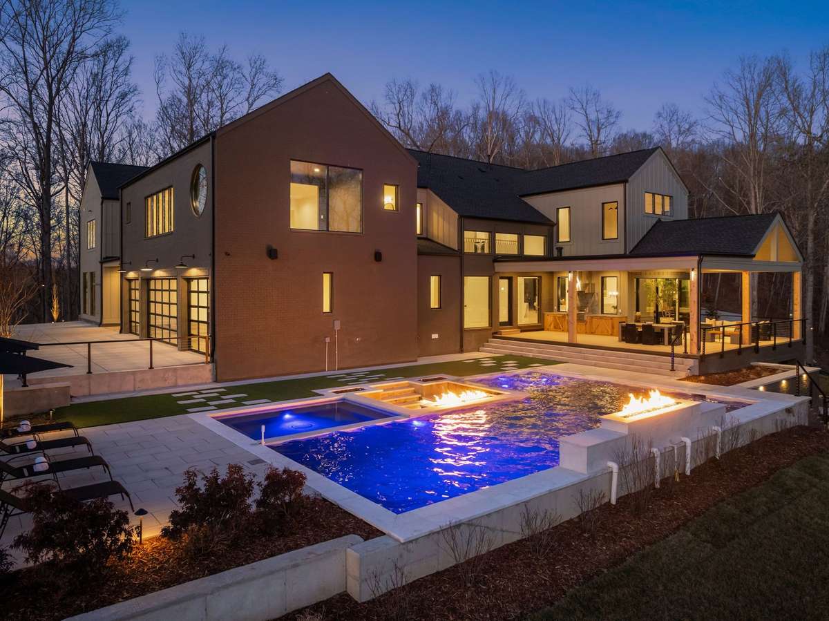 An outdoor setting that rivals a private resort, complete with fire features, pool, and seamless indoor outdoor living.